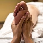 holding feet reflexology