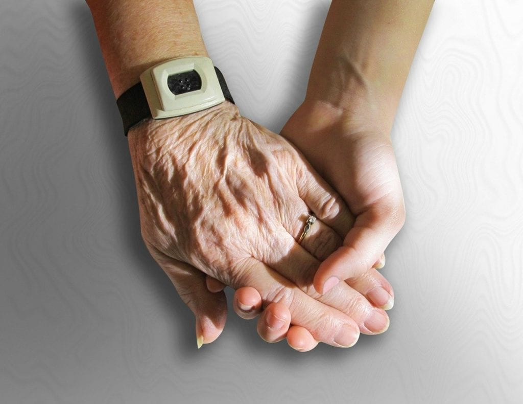 elderly holding hands