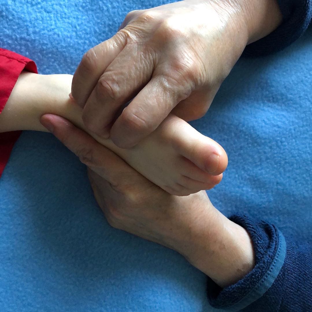 hands holding foot on blue blanket