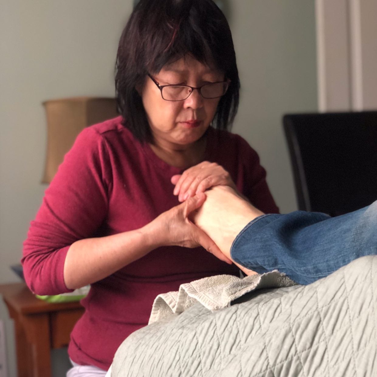 woman in red holding foot